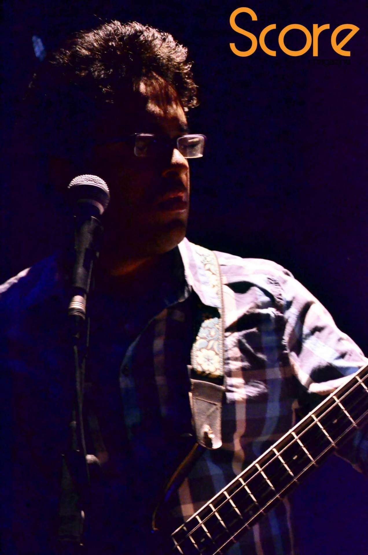 Hardhik singing and playing guitar on stage, Score magazine feature.
